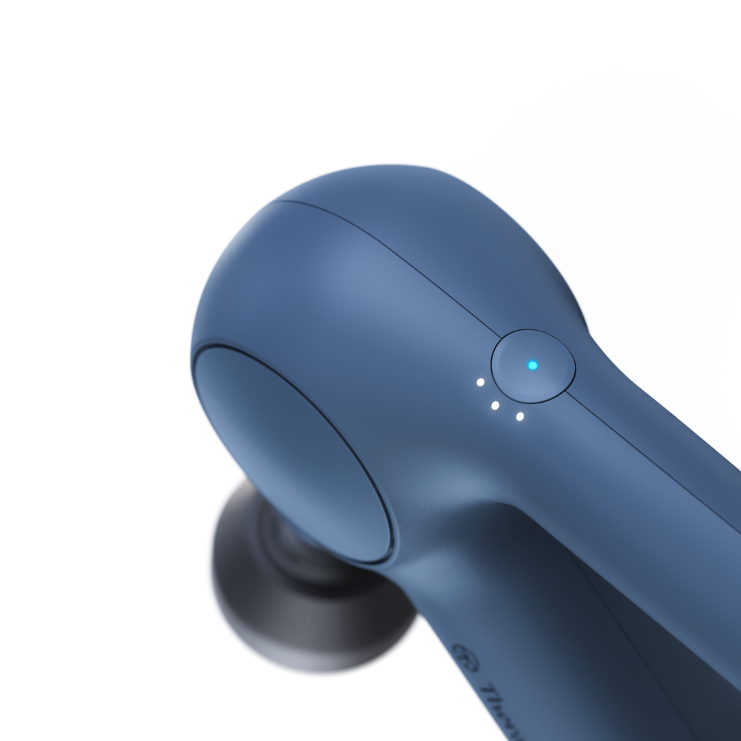 close up of the power button on the Therabody Theragun Relief in navy 