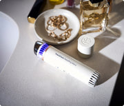White Therabody TheraFace Depuffing Wand on a vanity table