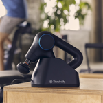 Load image into Gallery viewer, Therabody Theragun Prime Plus in charging stand on a table