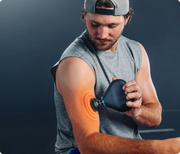 A man delivering heated percussive massage to his bicep with graphics displaying the heat and massage intensity