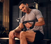 Man delivering 16mm percussive massage to his thigh with Therabody Theragun Prime Generation 6