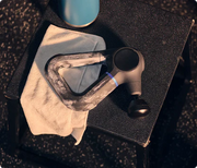 Therabody Theragun Prime Generation 6 on a gym towel with gym chalk on its handles