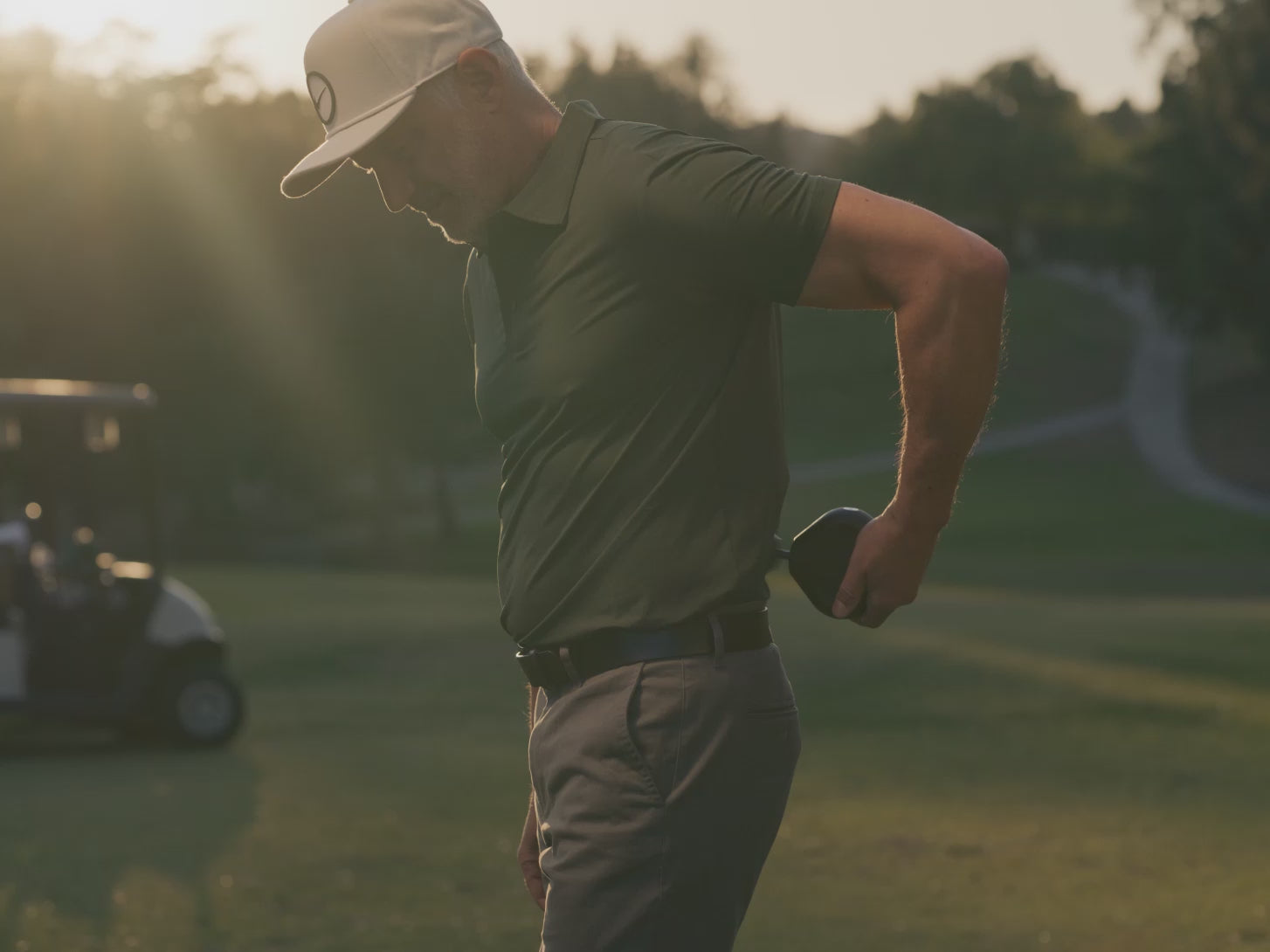 Man uses black Therabody Theragun Mini 3 on various parts of his body on a golf course